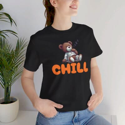 Model wearing a black t-shirt with a cute teddy bear and 'CHILL' graphic, perfect for casual comfort.