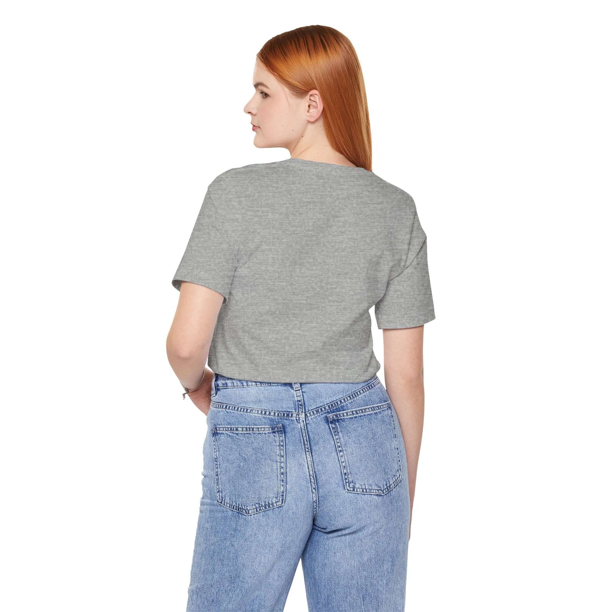 Back view of a woman in a grey Positive Vibe tee paired with high-waisted jeans, showcasing casual style.
