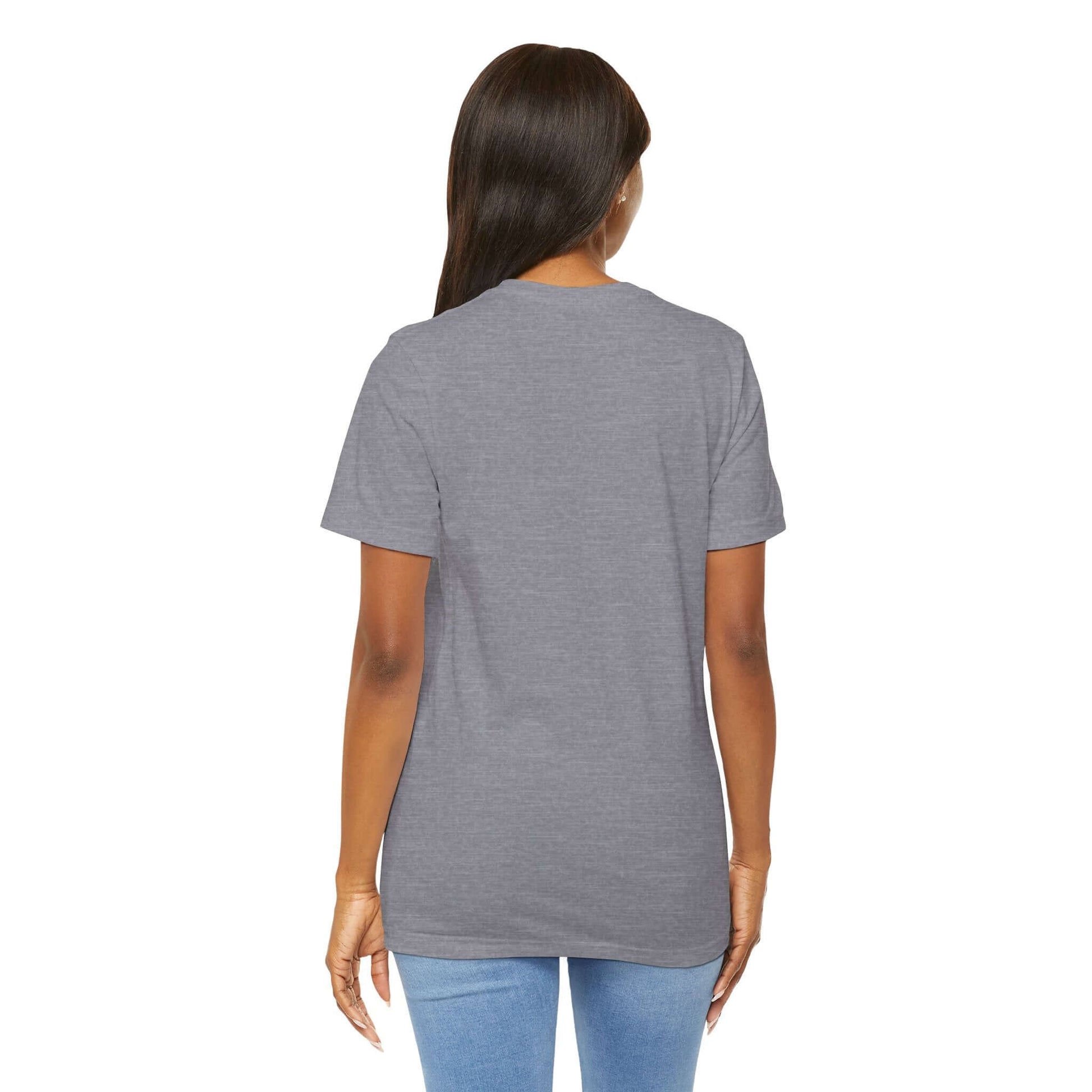 Back view of a woman wearing a gray graphic street style tee in casual urban fashion.