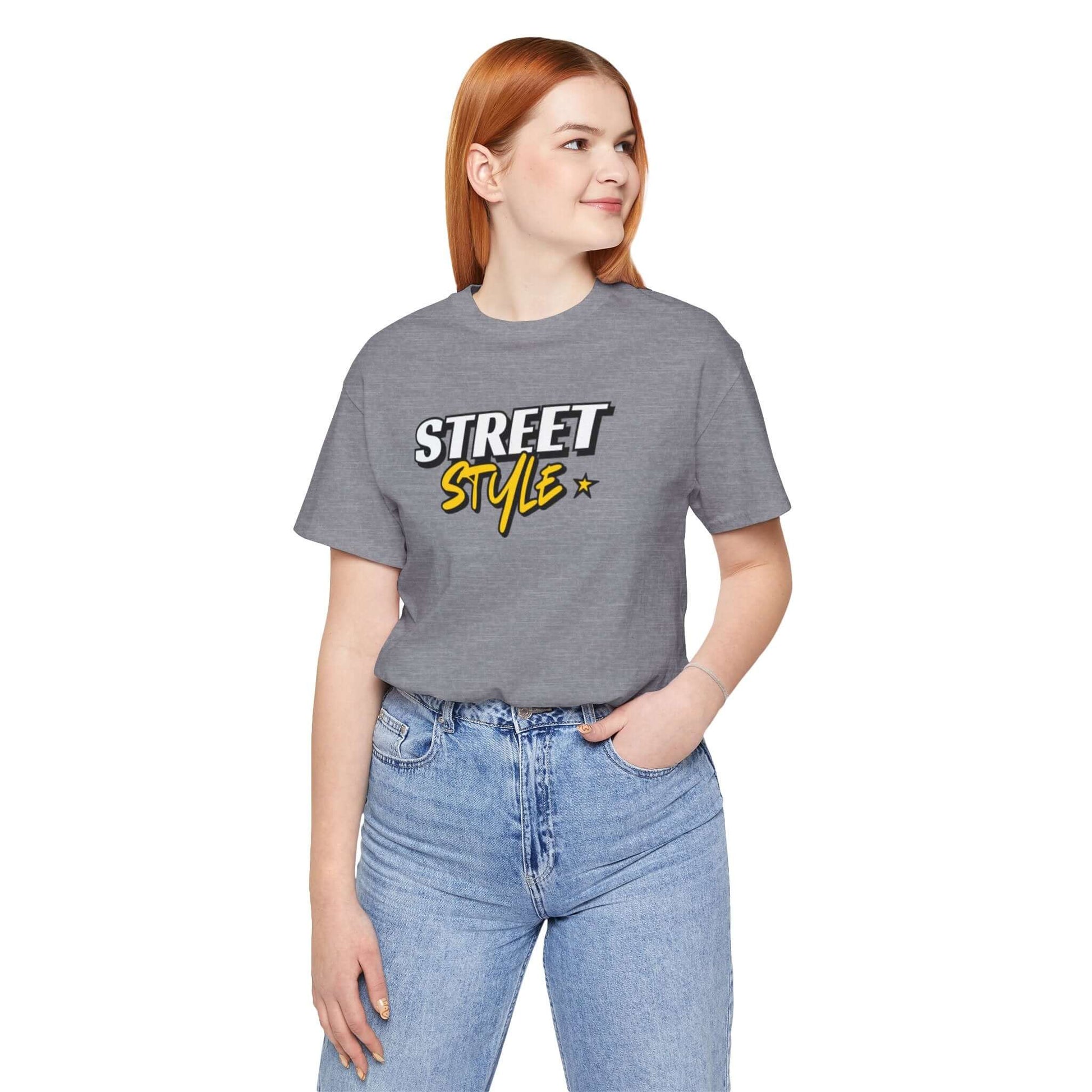Woman wearing a gray graphic tee featuring 'STREET STYLE' text, ideal for trendy urban fashion.
