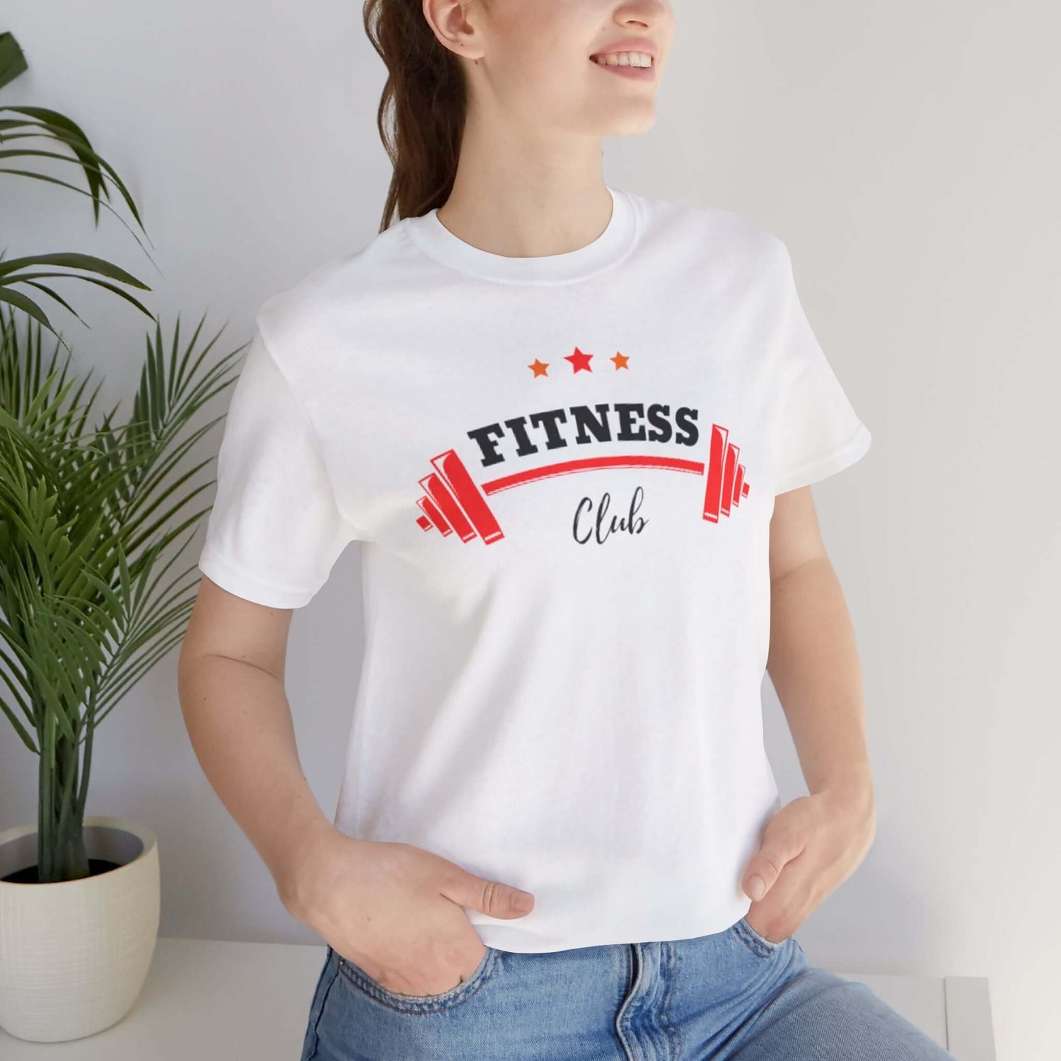 Woman wearing a white graphic Fitness Club T-shirt, showcasing bold gym-inspired design and a motivational message.