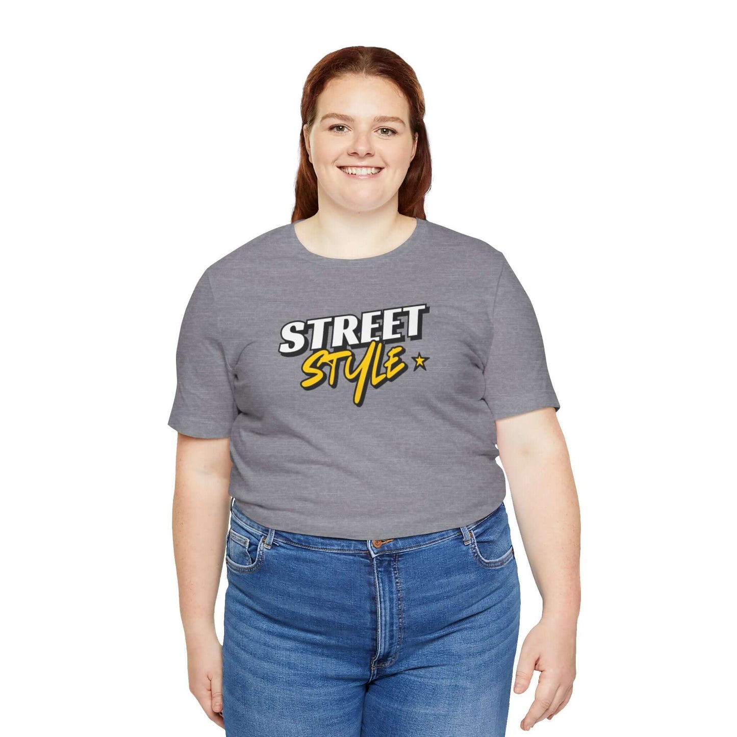 Woman wearing a gray street style graphic tee, showcasing trendy urban fashion in a casual setting.