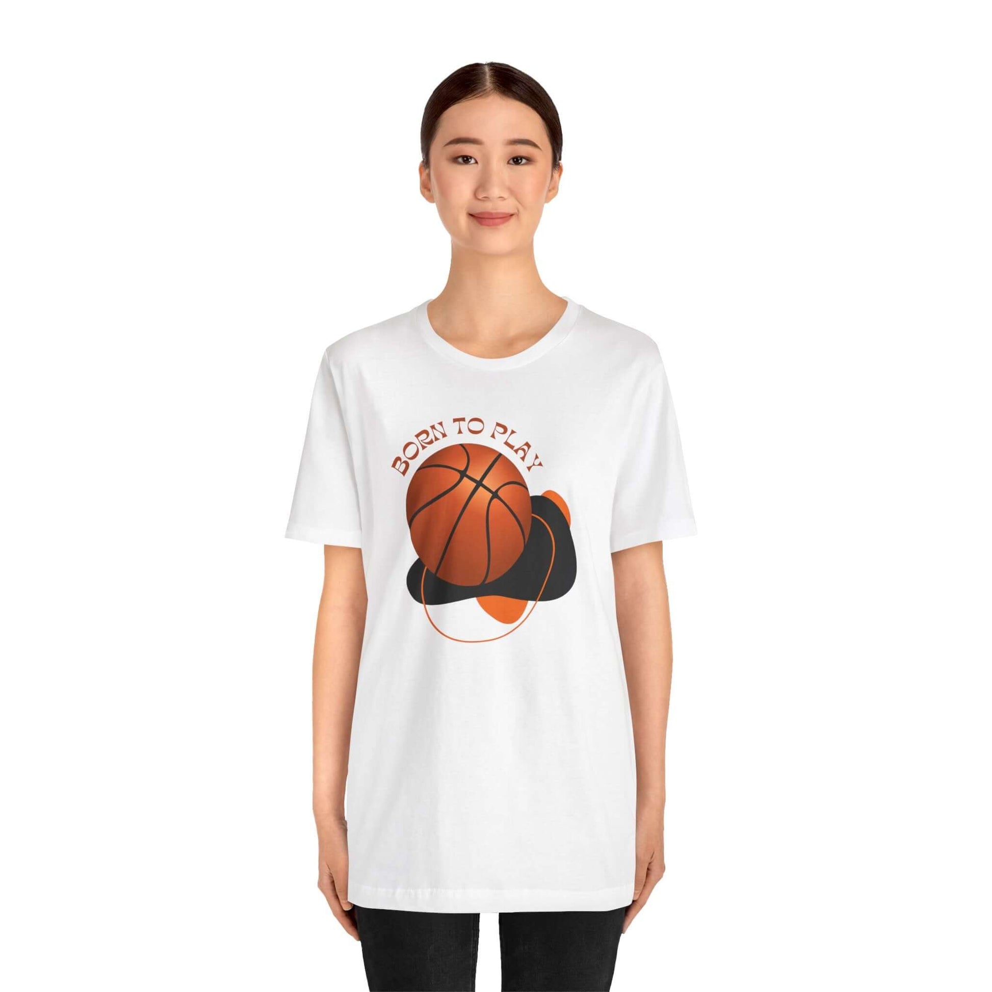 Model wearing a white unisex tee with 'Born to Play' graphic and basketball design, ideal for sports enthusiasts.
